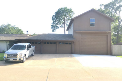 Garage - large traditional attached three-car garage idea in Houston