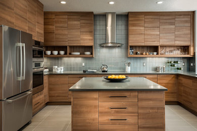 Kitchen - contemporary u-shaped kitchen idea in Calgary with an island, flat-panel cabinets, medium tone wood cabinets, gray backsplash, glass tile backsplash and stainless steel appliances