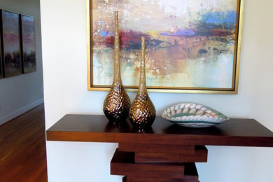 Example of a large trendy light wood floor foyer design in Louisville with white walls
