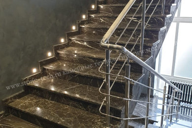 На фото: п-образная лестница с мраморными ступенями, подступенками из мрамора и металлическими перилами