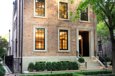 Transitional red two-story brick exterior home idea in Chicago with a metal roof