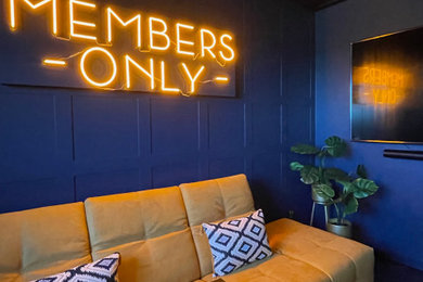 Diseño de sala de estar con barra de bar abierta moderna pequeña con paredes azules, suelo laminado, televisor colgado en la pared, suelo negro, papel pintado y panelado