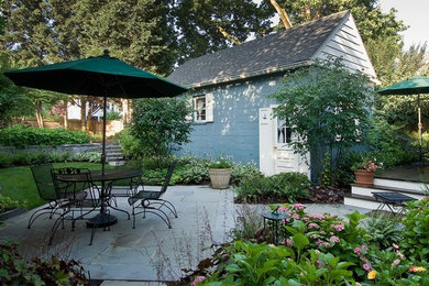 This is an example of a small traditional backyard partial sun garden for spring in DC Metro with natural stone pavers.
