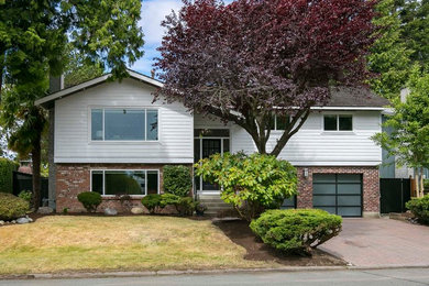 Mid-sized trendy white two-story gable roof photo in Vancouver