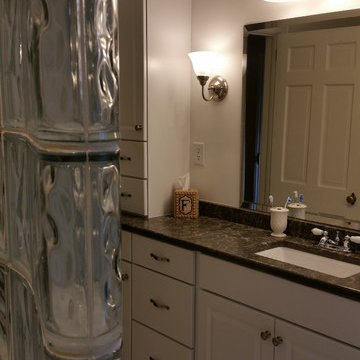Close up of glass block cured walk in shower and traditional cabinetry master ba