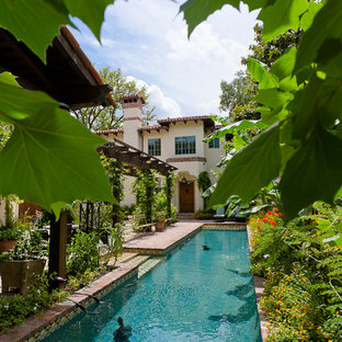 Inspiration för en stor rustik rektangulär träningspool på baksidan av huset, med marksten i tegel