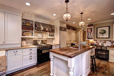 Inspiration for a large country l-shaped dark wood floor and brown floor enclosed kitchen remodel in Denver with a farmhouse sink, shaker cabinets, beige cabinets, granite countertops, beige backsplash, cement tile backsplash, stainless steel appliances and an island