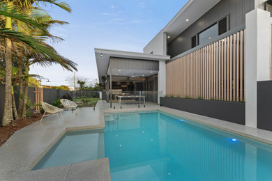 Design ideas for a contemporary front yard rectangular pool in Sunshine Coast with concrete slab.