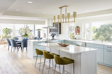 Eat-in kitchen - large transitional u-shaped brown floor and coffered ceiling eat-in kitchen idea in Other with an undermount sink, flat-panel cabinets, blue cabinets, stainless steel appliances and an island