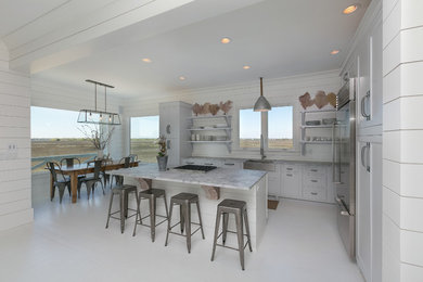 Design ideas for a beach style l-shaped eat-in kitchen in Charleston with a farmhouse sink, shaker cabinets, white cabinets, white splashback, stainless steel appliances and with island.