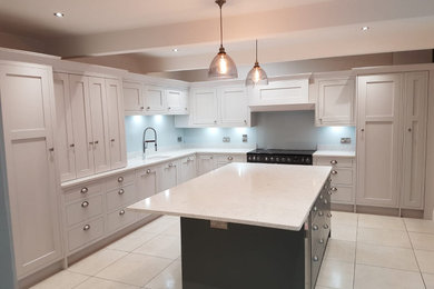 Design ideas for a medium sized open plan kitchen in West Midlands with a built-in sink, shaker cabinets, quartz worktops, glass tiled splashback, porcelain flooring and an island.