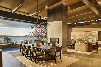 Inspiration for a contemporary concrete floor and gray floor dining room remodel in Seattle with beige walls and a two-sided fireplace