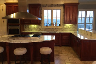 Mid-sized traditional l-shaped eat-in kitchen in Atlanta with raised-panel cabinets, dark wood cabinets, marble benchtops, grey splashback, stone tile splashback, stainless steel appliances and with island.
