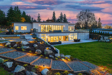 Huge minimalist white concrete fiberboard house exterior photo in Seattle with a metal roof and a brown roof