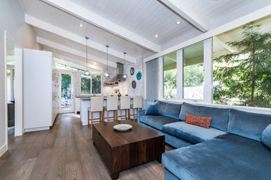 Family room - mid-sized contemporary enclosed medium tone wood floor and brown floor family room idea in San Francisco with a wall-mounted tv