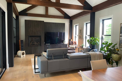 Idée de décoration pour un salon champêtre ouvert avec un mur blanc, un sol en bois brun, une cheminée standard et un téléviseur indépendant.