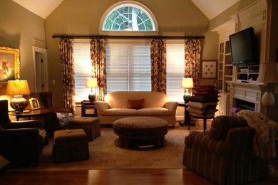Inspiration for a light wood floor living room remodel in Raleigh with beige walls, a standard fireplace, a plaster fireplace and a media wall