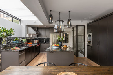 Contemporary kitchen in London with flat-panel cabinets, grey cabinets and an island.