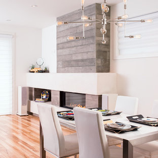 Inspiration for a contemporary dining room in Calgary with white walls, medium hardwood floors, a ribbon fireplace and a concrete fireplace surround.