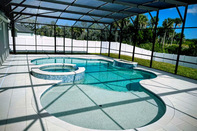 Example of a large tuscan backyard brick and custom-shaped natural pool design in Orlando