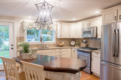 Inspiration for a small timeless l-shaped medium tone wood floor and brown floor enclosed kitchen remodel in Bridgeport with an undermount sink, raised-panel cabinets, white cabinets, granite countertops, beige backsplash, subway tile backsplash, stainless steel appliances and an island