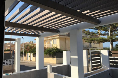 Diseño de terraza actual de tamaño medio con pérgola