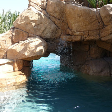 Rock Swimming Pool with Slide, Waterfall and a Table in the pool.