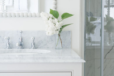 Inspiration for a small contemporary ensuite bathroom in Surrey with flat-panel cabinets, beige cabinets, a built-in shower, a one-piece toilet, multi-coloured tiles, marble worktops, grey worktops, a single sink and a freestanding vanity unit.