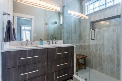 Example of a mid-sized transitional master beige tile and ceramic tile alcove shower design in Miami with flat-panel cabinets, dark wood cabinets, beige walls, an undermount sink, quartz countertops and a hinged shower door