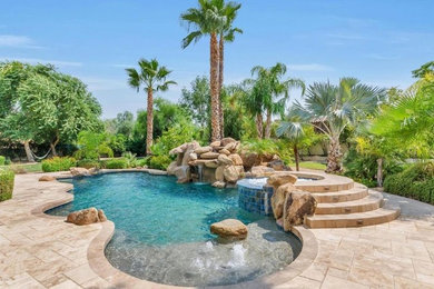 Example of a large minimalist backyard stamped concrete and custom-shaped hot tub design in Phoenix