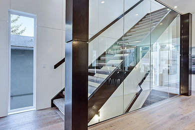 Trendy straight glass railing staircase photo in Calgary