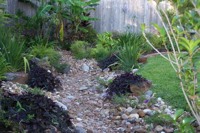 This is an example of a mid-sized modern partial sun backyard water fountain landscape in Austin for summer.