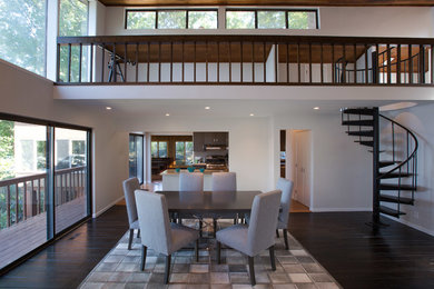 This is an example of a mid-sized contemporary open plan dining in Orange County with white walls, dark hardwood floors, no fireplace and brown floor.