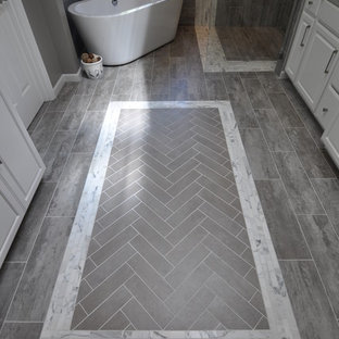 Immagine di una grande stanza da bagno padronale moderna con lavabo sottopiano, ante con bugna sagomata, ante bianche, top in quarzo composito, vasca freestanding, doccia a filo pavimento, piastrelle grigie, piastrelle in gres porcellanato, pareti grigie e pavimento in gres porcellanato