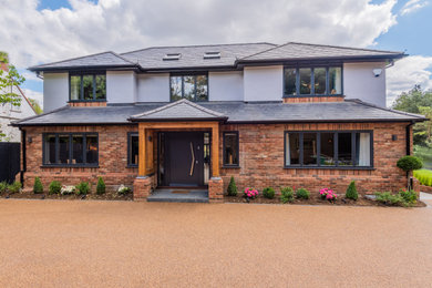 This is an example of a white and large bohemian two floor front and brick house exterior in Hertfordshire with a hip roof, a tiled roof and a grey roof.