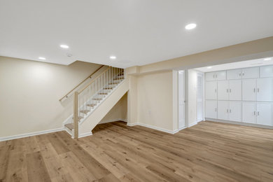 Inspiration for an underground vinyl floor and brown floor basement remodel in DC Metro with beige walls