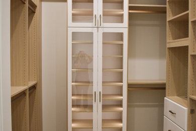 Mid-sized trendy walk-in closet photo in Miami with flat-panel cabinets and light wood cabinets