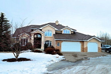 Inspiration for a mid-sized beige two-story stone exterior home remodel in Calgary