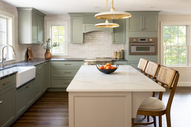 Kitchen - transitional kitchen idea in Boston with shaker cabinets, green cabinets, granite countertops, beige backsplash, mosaic tile backsplash, an island and gray countertops