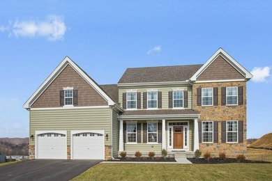 Large traditional green two-story stone house exterior idea in Wilmington with a shingle roof