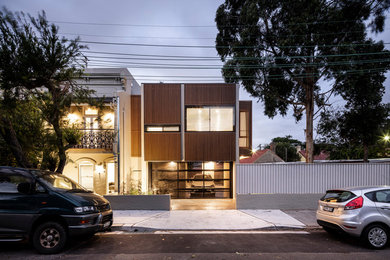 Photo of a contemporary two-storey green townhouse exterior in Sydney with wood siding and a flat roof.