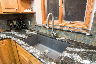 Inspiration for a mid-sized timeless l-shaped porcelain tile eat-in kitchen remodel in Other with a single-bowl sink, raised-panel cabinets, medium tone wood cabinets, quartz countertops, multicolored backsplash, porcelain backsplash, stainless steel appliances and an island