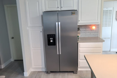 Example of a beach style single-wall eat-in kitchen design with an island