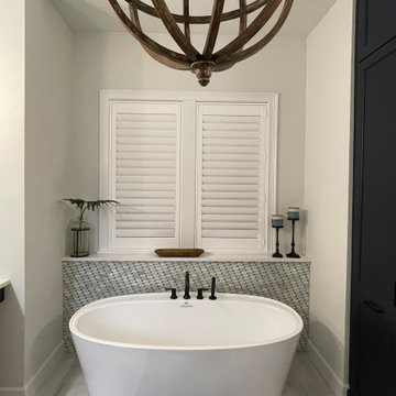 Soaking tub with tub shelf accented in Lunada Bay Glass Tile