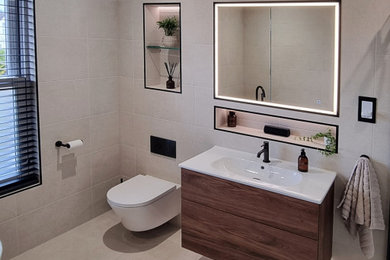 Medium sized bathroom in Surrey with recessed-panel cabinets, dark wood cabinets, a claw-foot bath, a built-in shower, a wall mounted toilet, beige tiles, cement tiles, grey walls, cement flooring, an integrated sink, engineered stone worktops, grey floors, an open shower, white worktops, a single sink and a built in vanity unit.