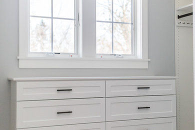 Example of a mid-sized transitional gender-neutral carpeted and gray floor walk-in closet design in Minneapolis with shaker cabinets and white cabinets