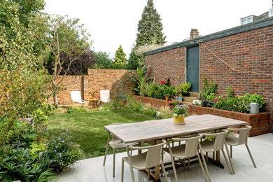 Imagen de patio actual de tamaño medio sin cubierta en patio trasero con suelo de baldosas