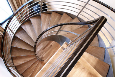 Photo of a contemporary wood spiral staircase in New York with open risers.