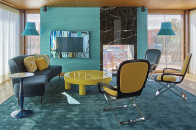 Imagen de sala de estar vintage con paredes azules, suelo de madera en tonos medios, chimenea de doble cara, marco de chimenea de piedra, pared multimedia, suelo marrón, madera y papel pintado