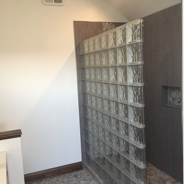 Glass block shower and ready for tile base and a pebble floor